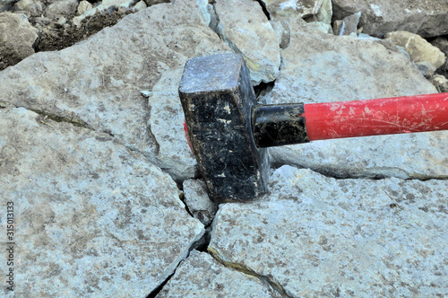 big iron hammer smashes stone