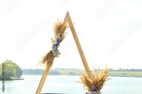 wedding arch with bouquets on the background of the river