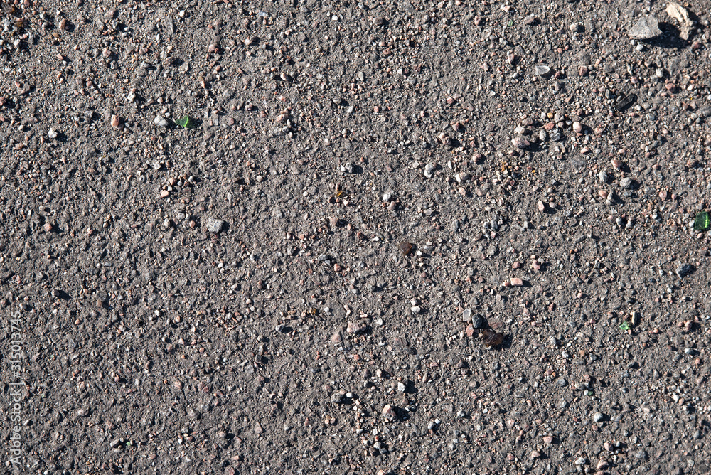 Texture: gray asphalt in sprinkled asphalt chips, small stones and other debris Texture: gray asphalt in sprinkled asphalt chips, small stones and other debris