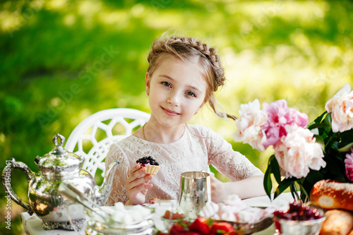 A girl eats a cake in the park.