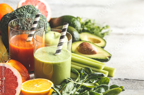 Green and orange detox smoothie in glass. Ingredients for detox smoothie background. Healthy food concept.