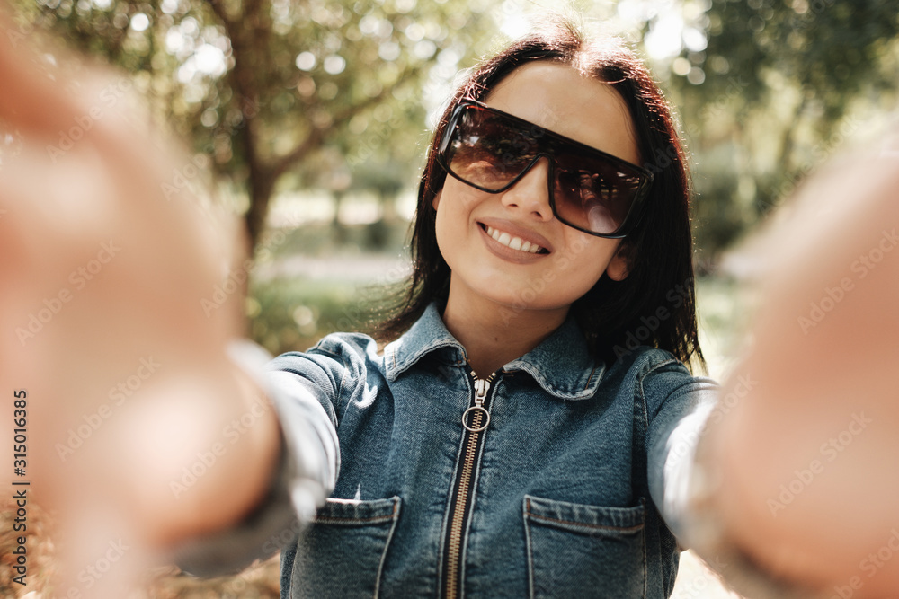 Close Up Portrait of One Beautiful Brunette Girl Dressed in Jeans Denim Overalls Walks in the Autumn Park Close Up Portrait of One Beautiful Brunette Girl Dressed in Jeans Denim Overalls Walks in the Autumn Park