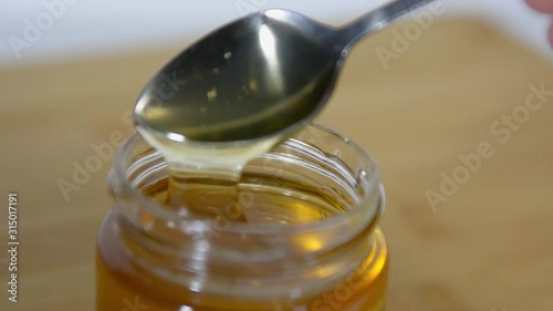 spoon is lowered into a jar of fragrant sweet honey and vypaskivaetsya from it. Honey drips from a spoon