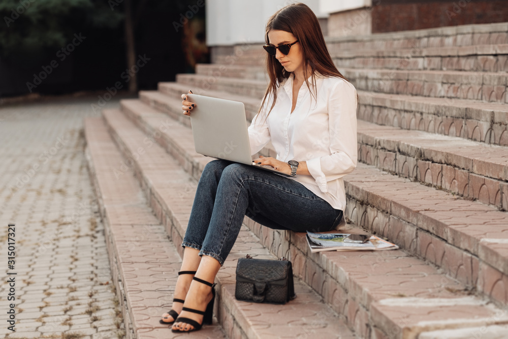 Portrait of One Fashionable Girl Dressed in Jeans and White Shirt Holding Laptop, Freelance Worker, Business Lady, Woman Power Concept
