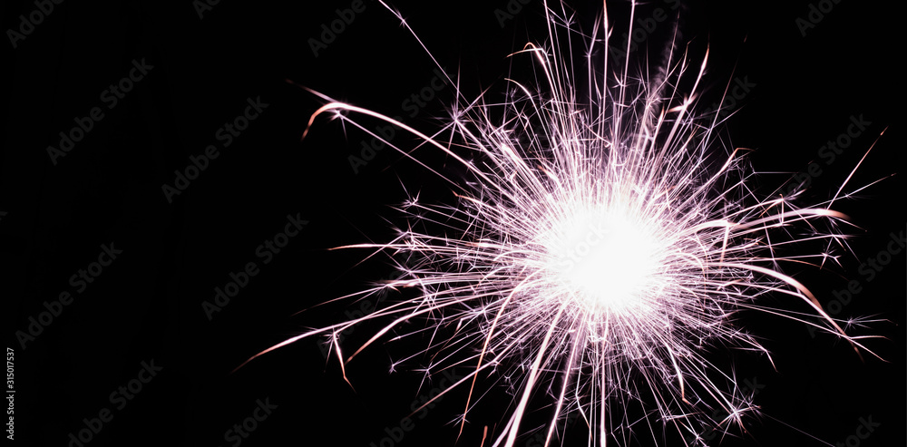bright festive new year Sparkler close up on a black background with a copy of the space