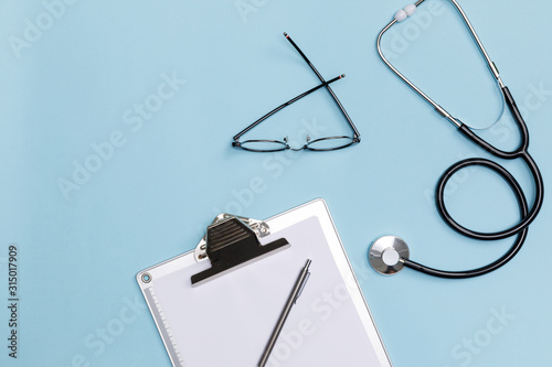 Creative flatlay of doctor medical equipment blue table with stethoscope, medical documents, Health care concept, Top view with copy space, Isolated on blue photo