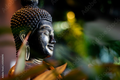 Fotografia buddha statue in interior garden at tropical bar in thailand
