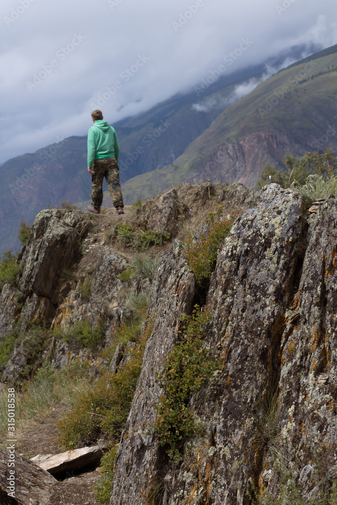hiker man on top of mountain vertical shot