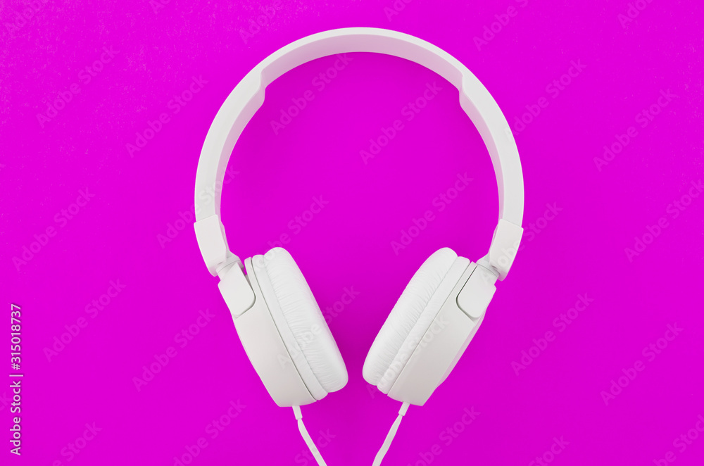 Modern white headphones on a purple background. Modern white headphones on a purple background.