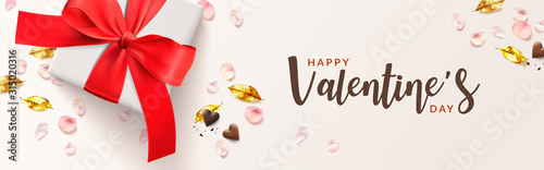 Happy valentine's day romantic banner. White gifts box and red bow, golden leaves, chocolate heart shape, pink rose petals. Realistic Vector illustration.