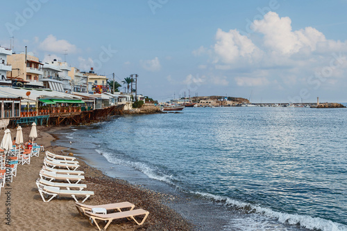sun loungers and umbrellas on a sandy beach in the Greek resort town of Hersonissos