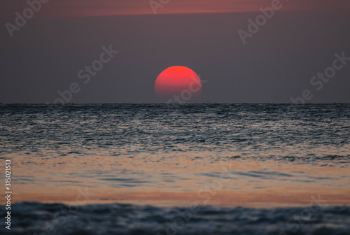 Fototapeta Naklejka Na Ścianę i Meble -  The orange sun is falling into the sea.