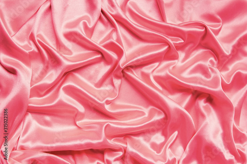 beautiful satin draped with soft folds fabric, silk cloth background, close-up, copy space