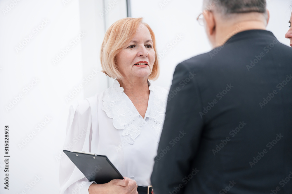 close up. business colleagues discussing something standing in the office lobby close up. business colleagues discussing something standing in the office lobby