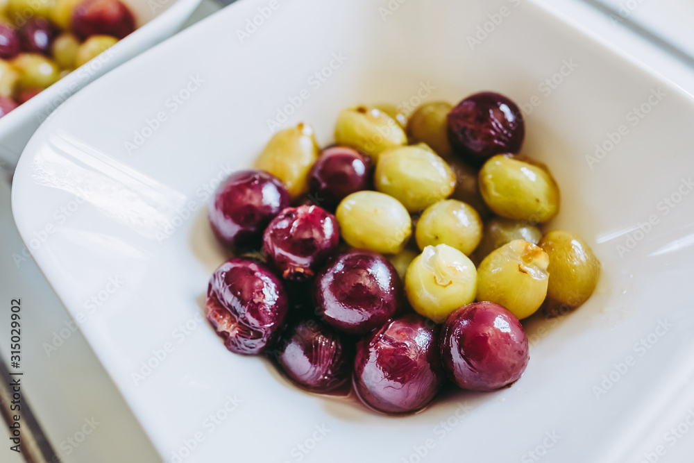 Dessert dans un bol, raisins blanc et rouge cuits au sucre Dessert dans un bol, raisins blanc et rouge cuits au sucre