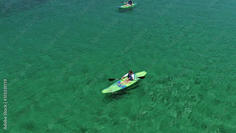 Group Kayaking in Traverse City Northern Michigan with blue sky clear fresh water people having lots of fun in the sun vacation travel trip up north for the summer warm activities bucket list epic
