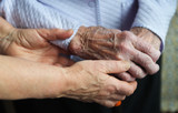 Hands of a mature wife or guardian holding the hands of her elderly woman or patient, as an expression of care and support.Close up photo of a dedicated caregiver holding an elderly woman's hands