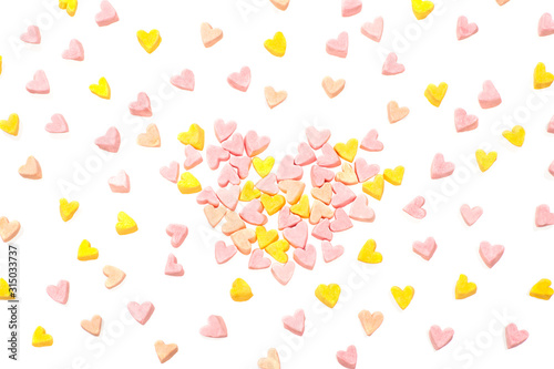 Fototapeta Naklejka Na Ścianę i Meble -  Many multi-colored marshmallows in the shape of hearts are scattered randomly.  Festive background.