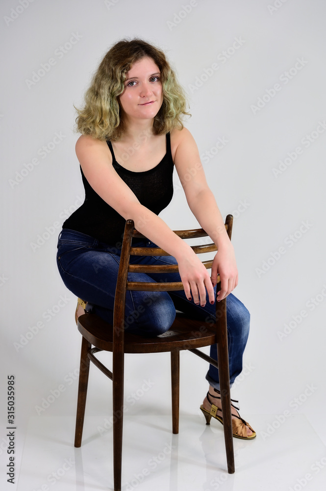 A young woman sits on a chair A young woman sits on a chair