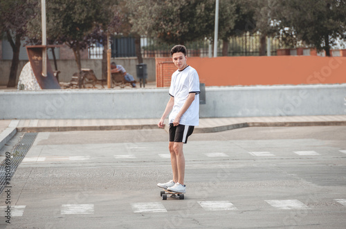 Portrait of a young and handsome guy with a Longboard, by the road.