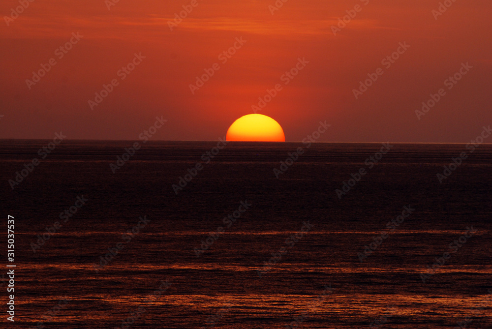 Nature seascape of Tranquil scene red sun and  red sky sunset over the sea at phuket Thailand.- Red orange nature backdrop and background concept