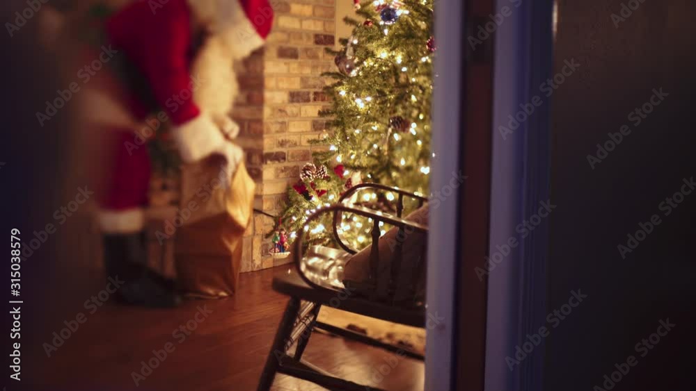 A child spying on Santa Claus delivering presents. A child spying on Santa Claus delivering presents.