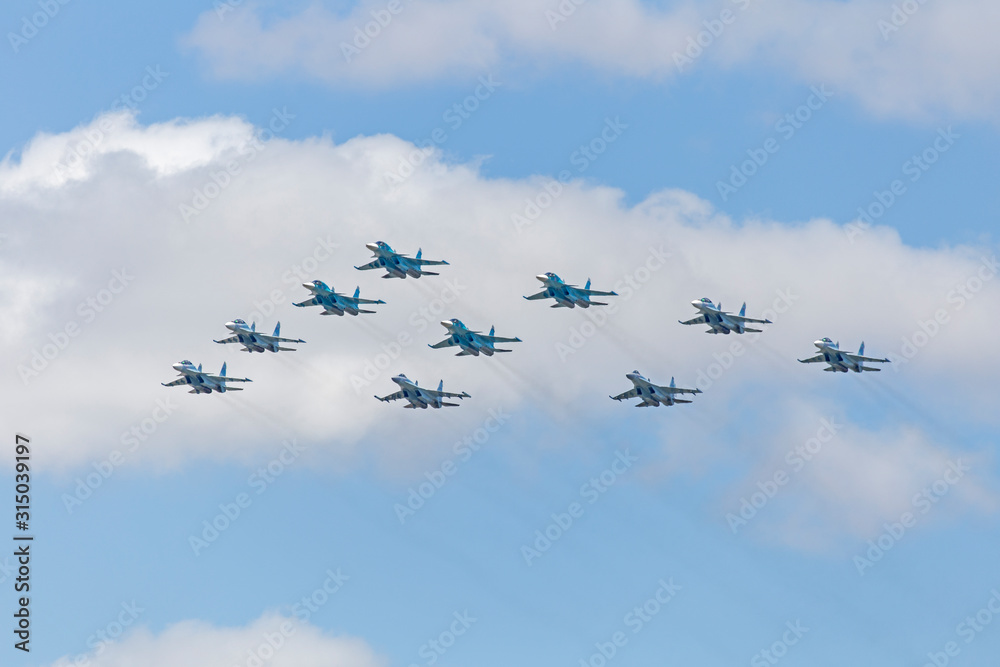 military plane and in the sky. MOSCOW, RUSSIA MAY 9, 2018: Su-30 SM and MiG-29 airplanes fireworks in the sky over the Red Square during the parade. military plane and in the sky. MOSCOW, RUSSIA MAY 9, 2018: Su-30 SM and MiG-29 airplanes fireworks in the sky over the Red Square during the parade.