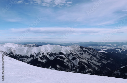 View on Vajskovska and Jasenianska valley from Chopok mountain in Low Tatras, Slovakia. Fairy-tale landscape with many snowy hills and sky with many shadows of blue. Paradise same as in Alps photo