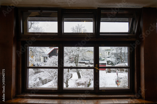View of the completely snow-covered street through a window