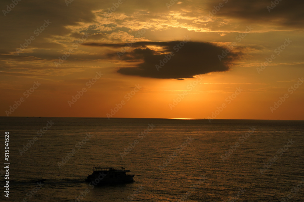 Nature seascape of Tranquil scene Sun behind the dark clouds and twilight sky sunset  over the sea at phuket Thailand. - Travel nature backdrops                               