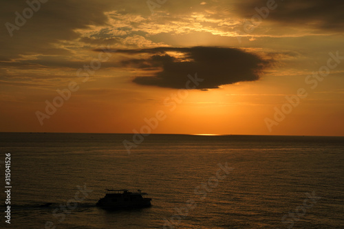Nature seascape of Tranquil scene Sun behind the dark clouds and twilight sky sunset over the sea at phuket Thailand. - Travel nature backdrops 