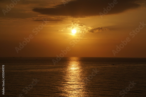 Nature seascape of Tranquil sunset scene. Sun and dark clouds with twilight sky over the sea at phuket Thailand - image backdrop background and copy space                            © kittinit