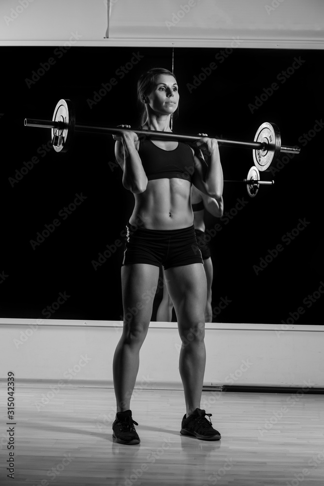 young strong girl raises the barbell