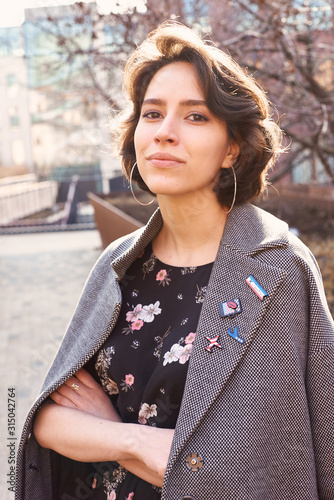Summer sunny lifestyle fashion portrait of young stylish hipster woman walking on the street