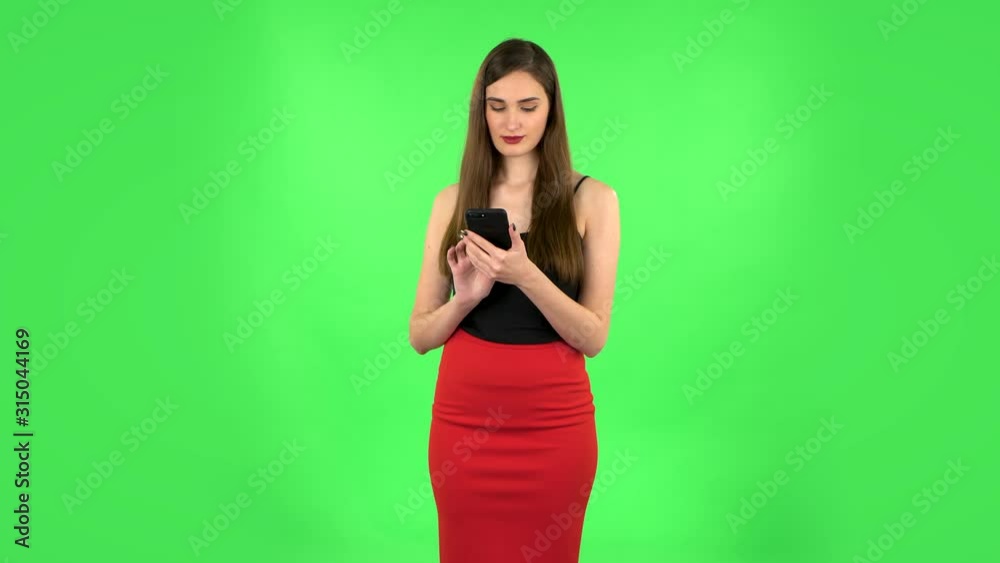 Young woman texting on her phone and shocked. Green screen Young woman texting on her phone and shocked. Green screen
