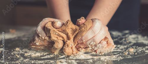 Canvas Print girl preparing cookies in the shape of a heart for the holiday Valentine's Day at home, in a small bakery, family business, authentic, hobby, mood, cozy