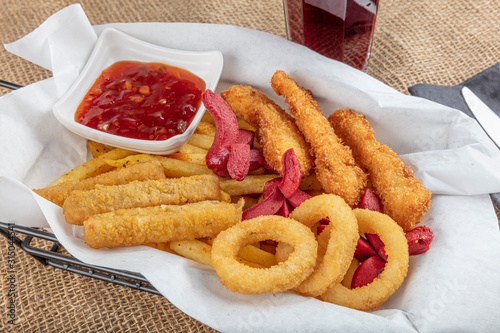 Snack platter - French fries,  spring rolls, fried sausage, chicken nugget, Turkish pastry, onion rings, potato croquette on plate. photo