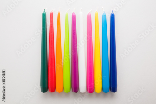 Colorful new candles on light gray table. Closeup. photo