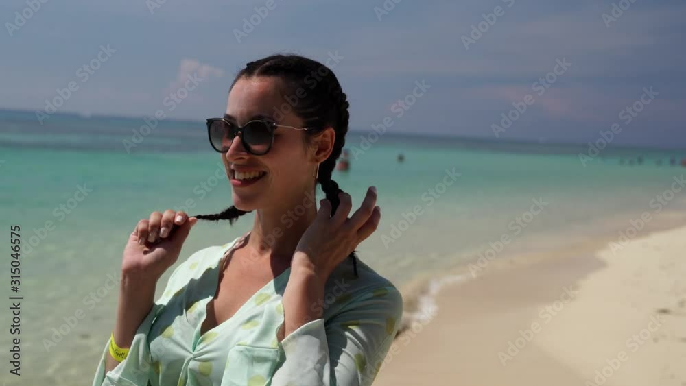 portrait of woman laughing enjoying lifestyle looking at camera on calm beach portrait of woman laughing enjoying lifestyle looking at camera on calm beach