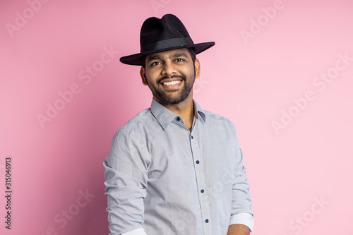 Portrait of handsome Indian guy standing on pink background © liliyabatyrova