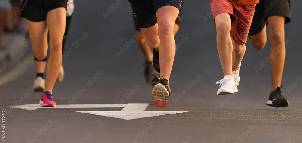 Running children, young athletes run in a kids run race,running on city road detail on legs