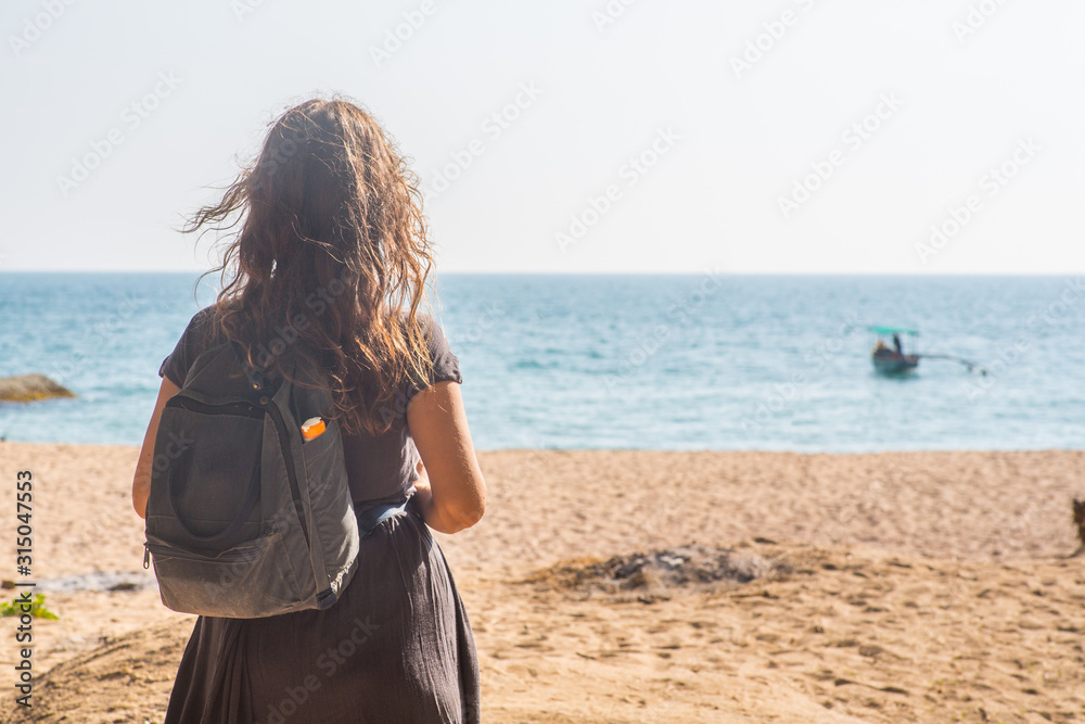 Girl at a beach with a backpack Girl at a beach with a backpack