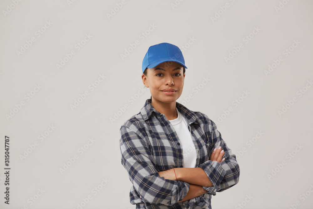 Waist up portrait of beautiful female worker smiling at camera while posing confidently against white background standing with arms crossed, copy space Waist up portrait of beautiful female worker smiling at camera while posing confidently against white background standing with arms crossed, copy space