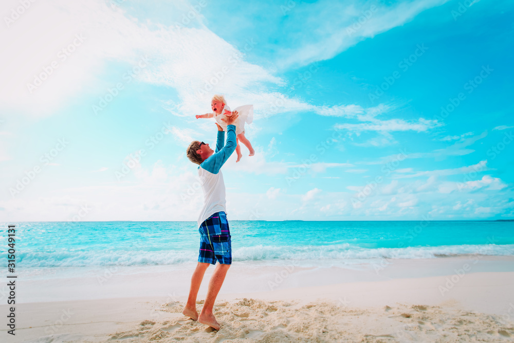 father and cute little daughter play at beach father and cute little daughter play at beach