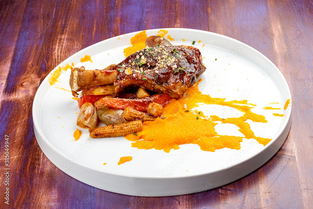 Lamb shank with demiglas sauce, carrot puree with caramelized vegetables Lamb shank with demiglas sauce, carrot puree with caramelized vegetables