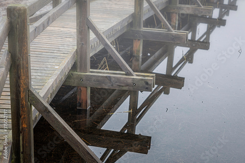 Wooden dock leads to bird tower in mist