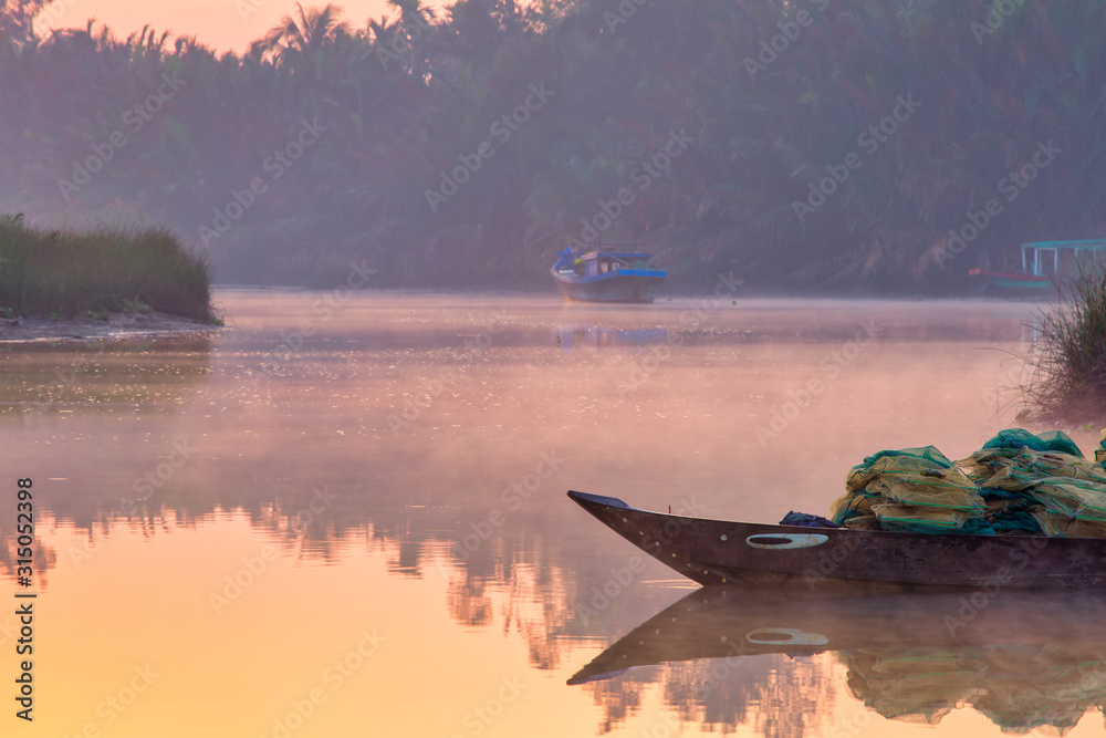 Vietnamese misty river with fishing boats and nets. Hoi An neighborhood, at sunrise. Vietnamese misty river with fishing boats and nets. Hoi An neighborhood, at sunrise.