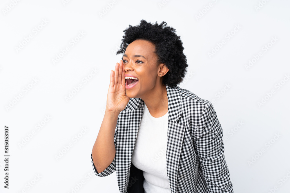 African american woman with blazer over isolated white background shouting with mouth wide open to the lateral African american woman with blazer over isolated white background shouting with mouth wide open to the lateral