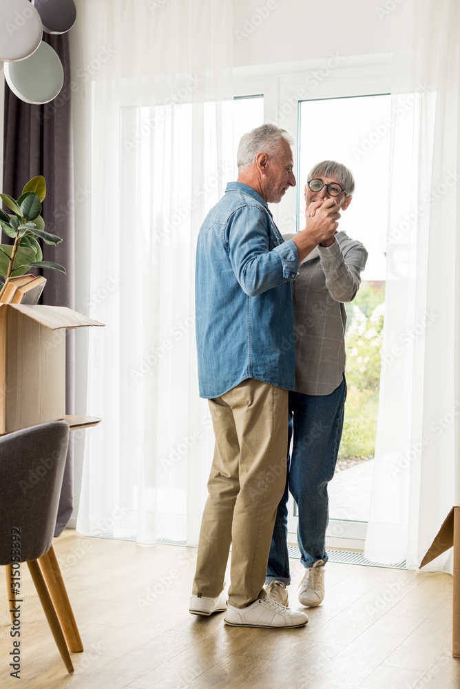 mature man and smiling woman dancing in new house mature man and smiling woman dancing in new house
