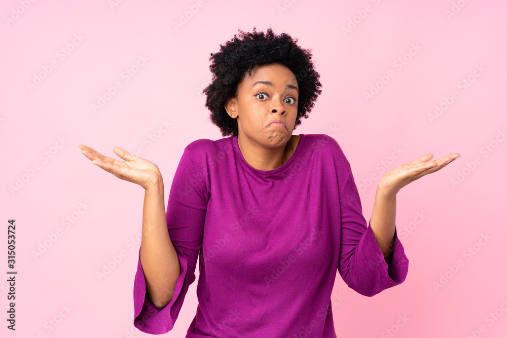 African american woman over isolated pink background making doubts gesture